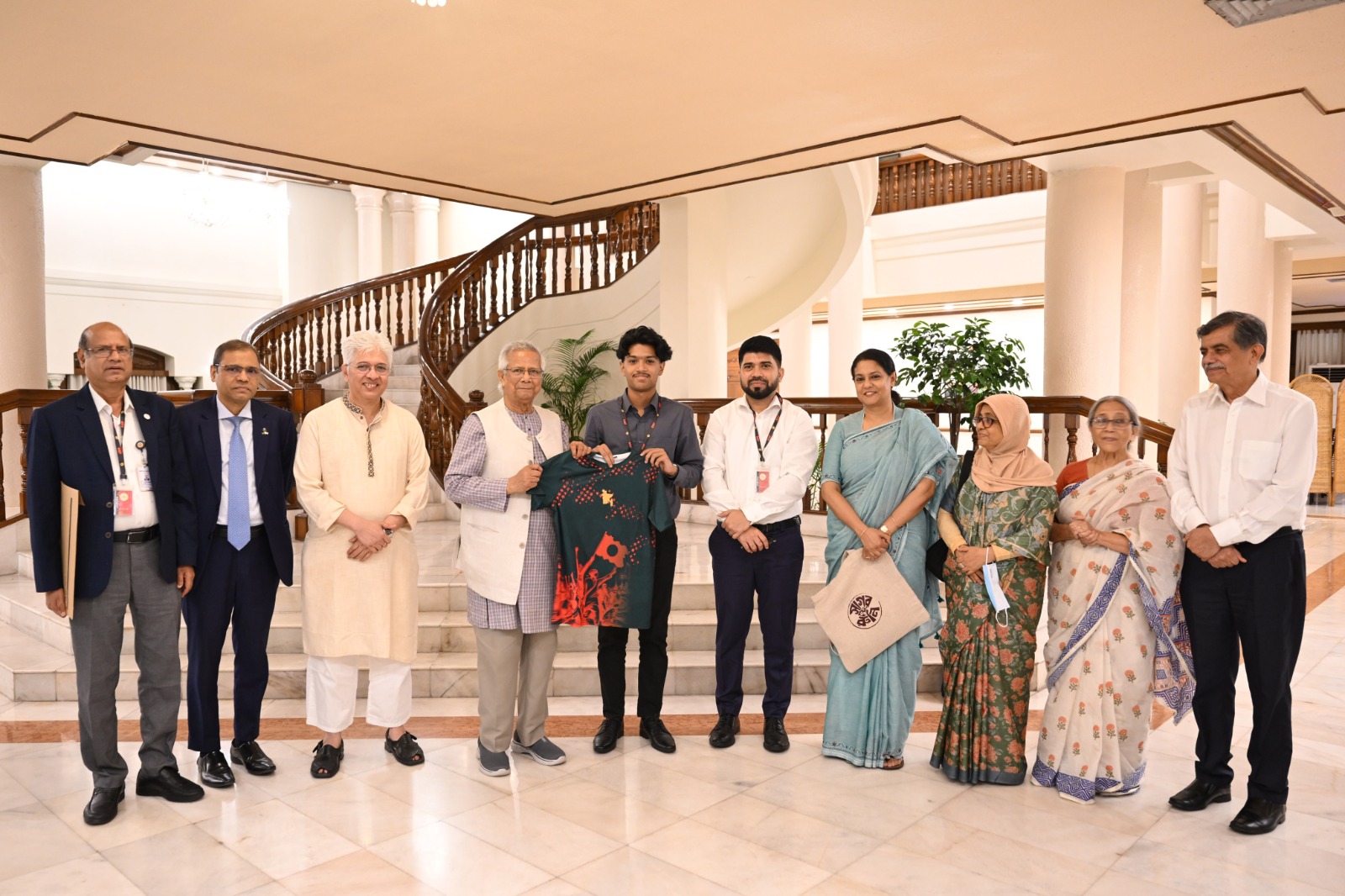 Mahir Sarowar Megh presents a jersey and bag to Chief Adviser Professor Muhammad Yunus. Also present: Chowdhury Rafiqul Abrar, Farida Akhter, Syeda Rizwana Hasan, Engineer Md. Riazul Islam, and Nowazesh Alam Roman. Photo AH Mintu/V7N